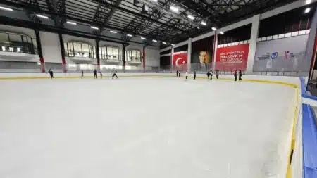 Ankara’da Buz Pateni Yapabileceğiniz Yerler: Pistler, Kurslar ve Fiyatlar (Güncel) BelPa Buz Pisti’nin geniş kapalı buz pisti: çelik çatı makasları, pistin uzak kenarında kayan birkaç kişi, Türk bayrağı, Atatürk posteri ve Ankara Büyükşehir Belediyesi logolu panolar