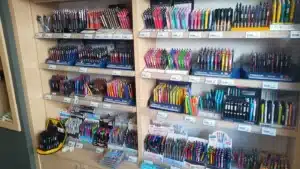 Çamlıca Kitap Kırtasiye’nin Ulus’taki mağazasında ahşap raflarda renk renk dizilmiş tükenmez, jel ve versatil kalemler; Pensan ve Faber-Castell standları