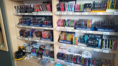 Çamlıca Kitap Kırtasiye’nin Ulus’taki mağazasında ahşap raflarda renk renk dizilmiş tükenmez, jel ve versatil kalemler; Pensan ve Faber-Castell standları