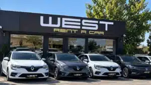 Eryaman’daki WEST Rent A Car ofisinin siyah cephesi ve önünde sıralanmış beyaz ve gri Renault Megane ile Volkswagen Passat kiralık araçlar