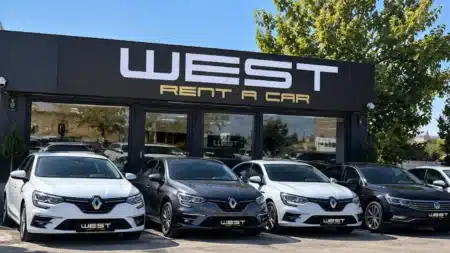 Eryaman’daki WEST Rent A Car ofisinin siyah cephesi ve önünde sıralanmış beyaz ve gri Renault Megane ile Volkswagen Passat kiralık araçlar